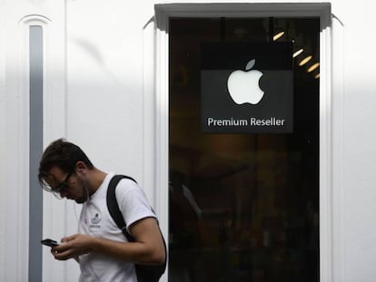 Un hombre consulta su móvil delante de una tienda de Apple en Galway, Irlanda, en una fotografía de archivo.